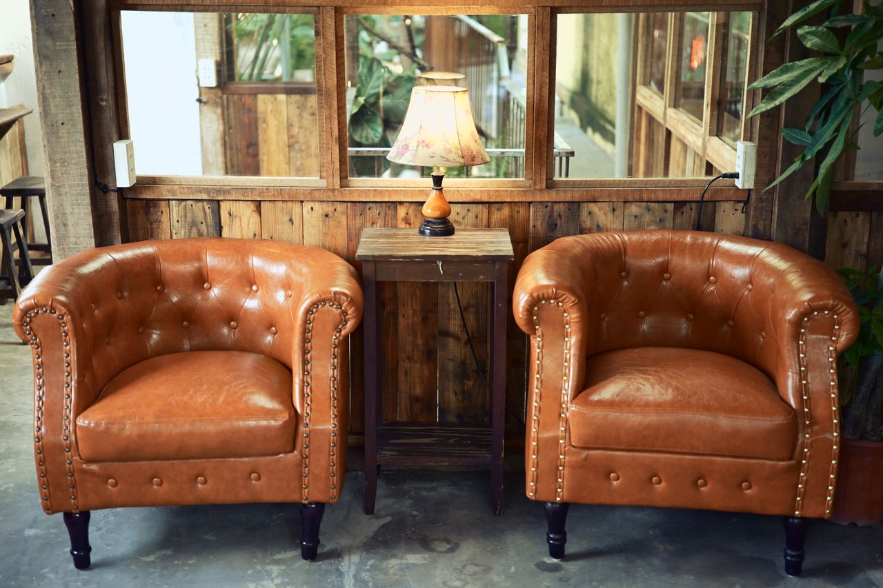 about-07 Inviting rustic lounge setup with leather armchairs and a wooden lamp for a warm ambiance.
